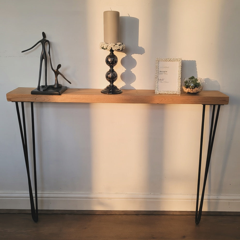 Wooden console table with decorative items against a plain wall